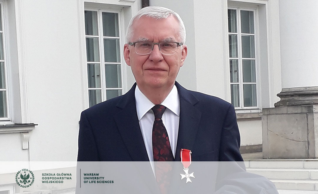 Poważny starszy mężczyzna w okularach w garniturze odznaczony krzyżem Kawalerskim Orderu Odrodzenia Polski