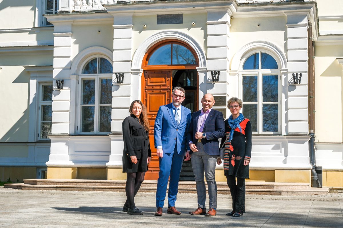 Cztery osoby pozujące na tle Pałacu Rektorskiego SGGW.